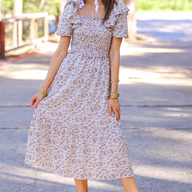 a lightweight ditsy floral midi dress with a smocked bodice, square neckline, ruffled trim and cap sleeves (wearable on or off the shoulder), and a relaxed silhouette that falls into a mid-calf hemline