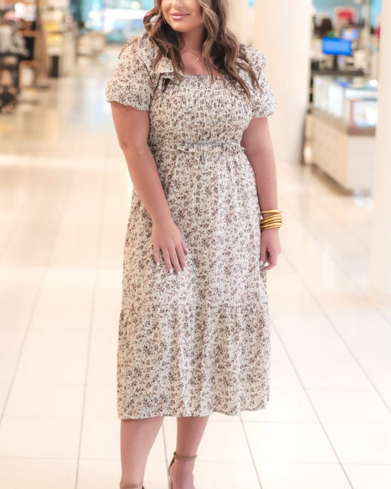 a lightweight ditsy floral midi dress with a smocked bodice, square neckline, ruffled trim and cap sleeves (wearable on or off the shoulder), and a relaxed silhouette that falls into a mid-calf hemline