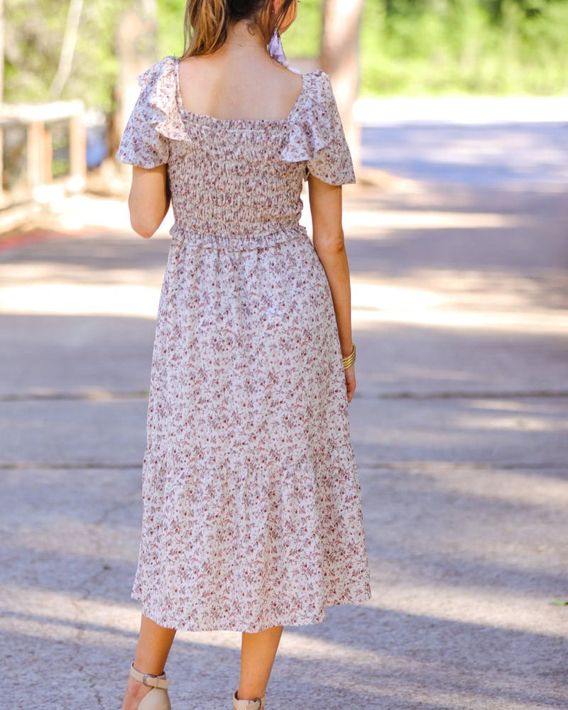 a lightweight ditsy floral midi dress with a smocked bodice, square neckline, ruffled trim and cap sleeves (wearable on or off the shoulder), and a relaxed silhouette that falls into a mid-calf hemline