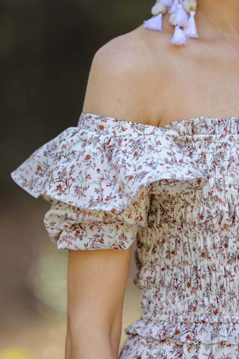 a lightweight ditsy floral midi dress with a smocked bodice, square neckline, ruffled trim and cap sleeves (wearable on or off the shoulder), and a relaxed silhouette that falls into a mid-calf hemline