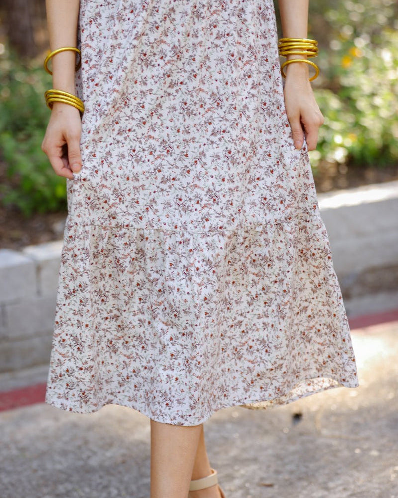 a lightweight ditsy floral midi dress with a smocked bodice, square neckline, ruffled trim and cap sleeves (wearable on or off the shoulder), and a relaxed silhouette that falls into a mid-calf hemline