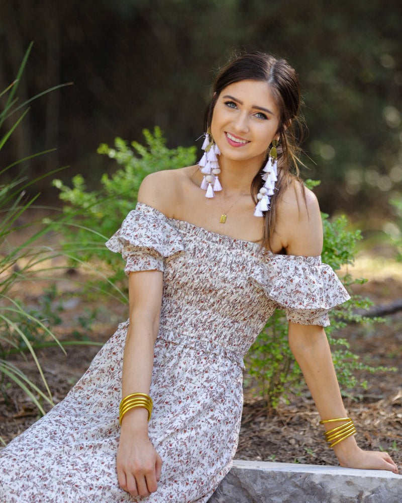 a lightweight ditsy floral midi dress with a smocked bodice, square neckline, ruffled trim and cap sleeves (wearable on or off the shoulder), and a relaxed silhouette that falls into a mid-calf hemline