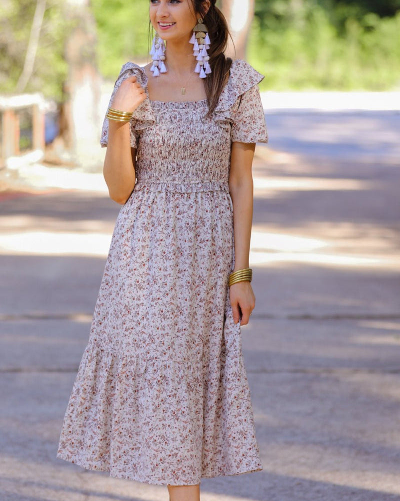 a lightweight ditsy floral midi dress with a smocked bodice, square neckline, ruffled trim and cap sleeves (wearable on or off the shoulder), and a relaxed silhouette that falls into a mid-calf hemline