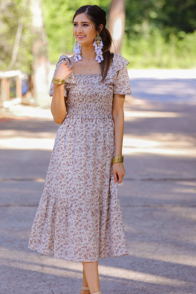 a lightweight ditsy floral midi dress with a smocked bodice, square neckline, ruffled trim and cap sleeves (wearable on or off the shoulder), and a relaxed silhouette that falls into a mid-calf hemline