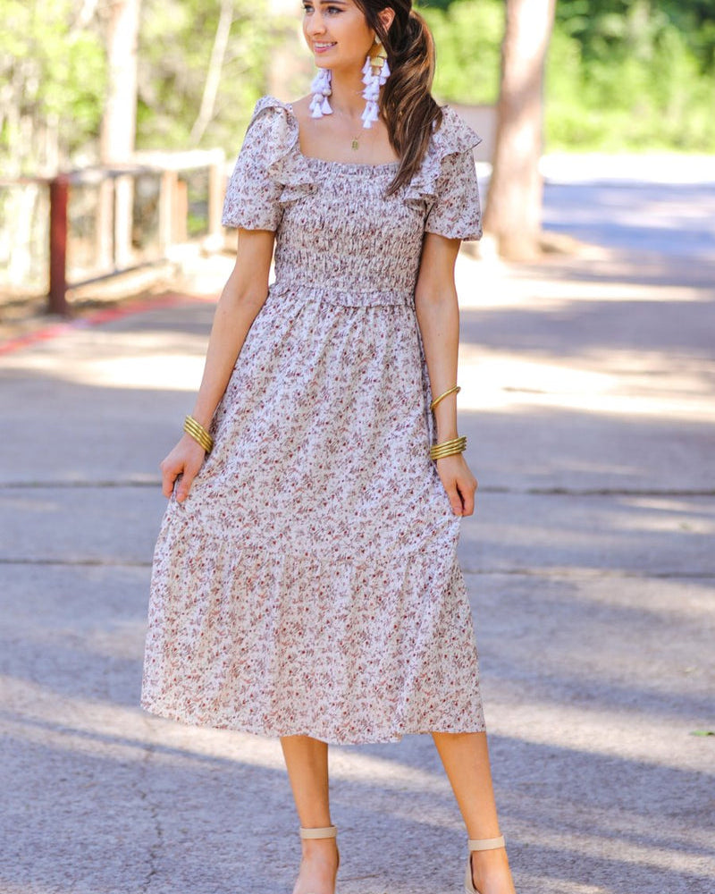 a lightweight ditsy floral midi dress with a smocked bodice, square neckline, ruffled trim and cap sleeves (wearable on or off the shoulder), and a relaxed silhouette that falls into a mid-calf hemline