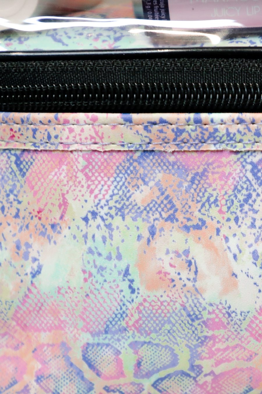 two-tier design with a clear compartment, four brush slots with an elastic band on the inside lid of the main compartment, and a grab-and-go handle with dual gold zippers in a soft pastel snakeskin print