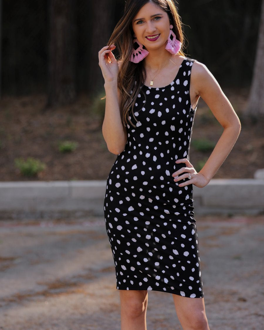 a lightweight midi bodycon dress with a flattering ribbed knit, a sleeveless silhouette, and a scoop neckline on a solid black base and white polka dot print fabric