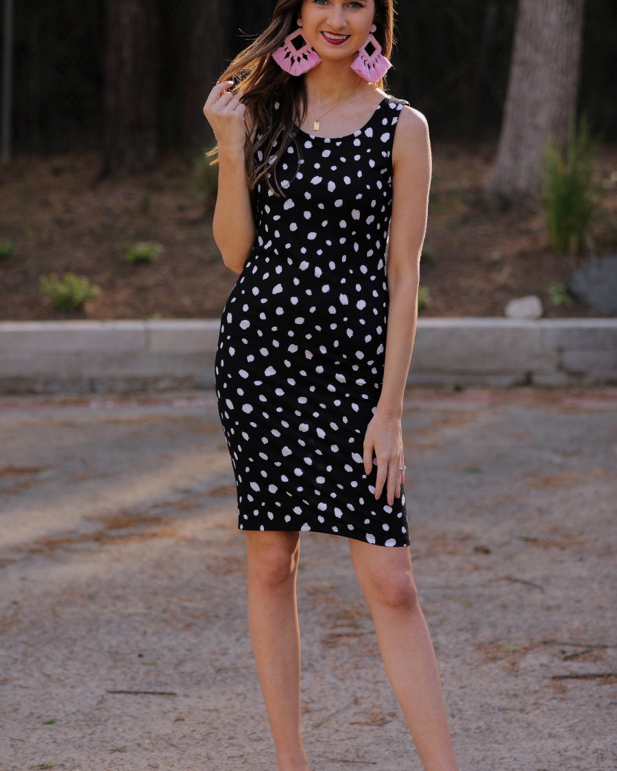 a lightweight midi bodycon dress with a flattering ribbed knit, a sleeveless silhouette, and a scoop neckline on a solid black base and white polka dot print fabric