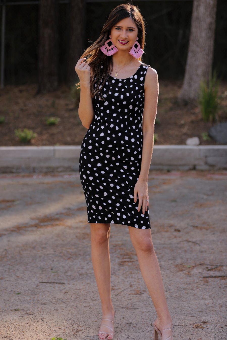 a lightweight midi bodycon dress with a flattering ribbed knit, a sleeveless silhouette, and a scoop neckline on a solid black base and white polka dot print fabric