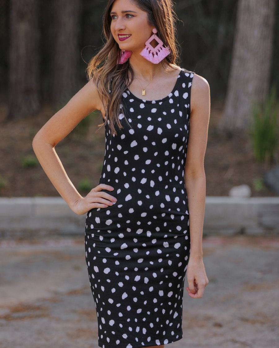 a lightweight midi bodycon dress with a flattering ribbed knit, a sleeveless silhouette, and a scoop neckline on a solid black base and white polka dot print fabric