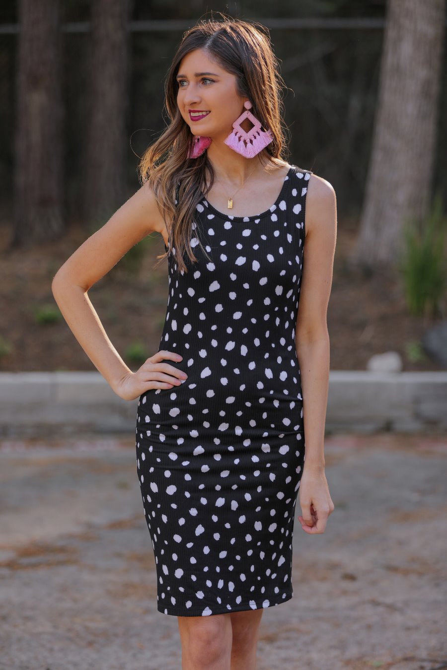 a lightweight midi bodycon dress with a flattering ribbed knit, a sleeveless silhouette, and a scoop neckline on a solid black base and white polka dot print fabric