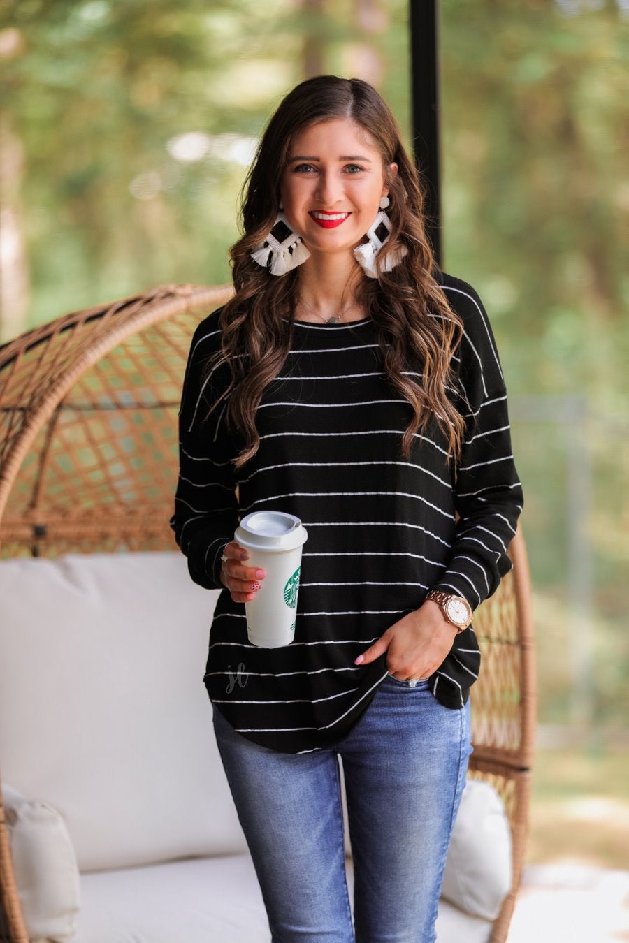 lightweight horizontal striped top with long sleeves, a crew neckline, and a slouched silhouette that ends in a rounded hemline on a solid black base
