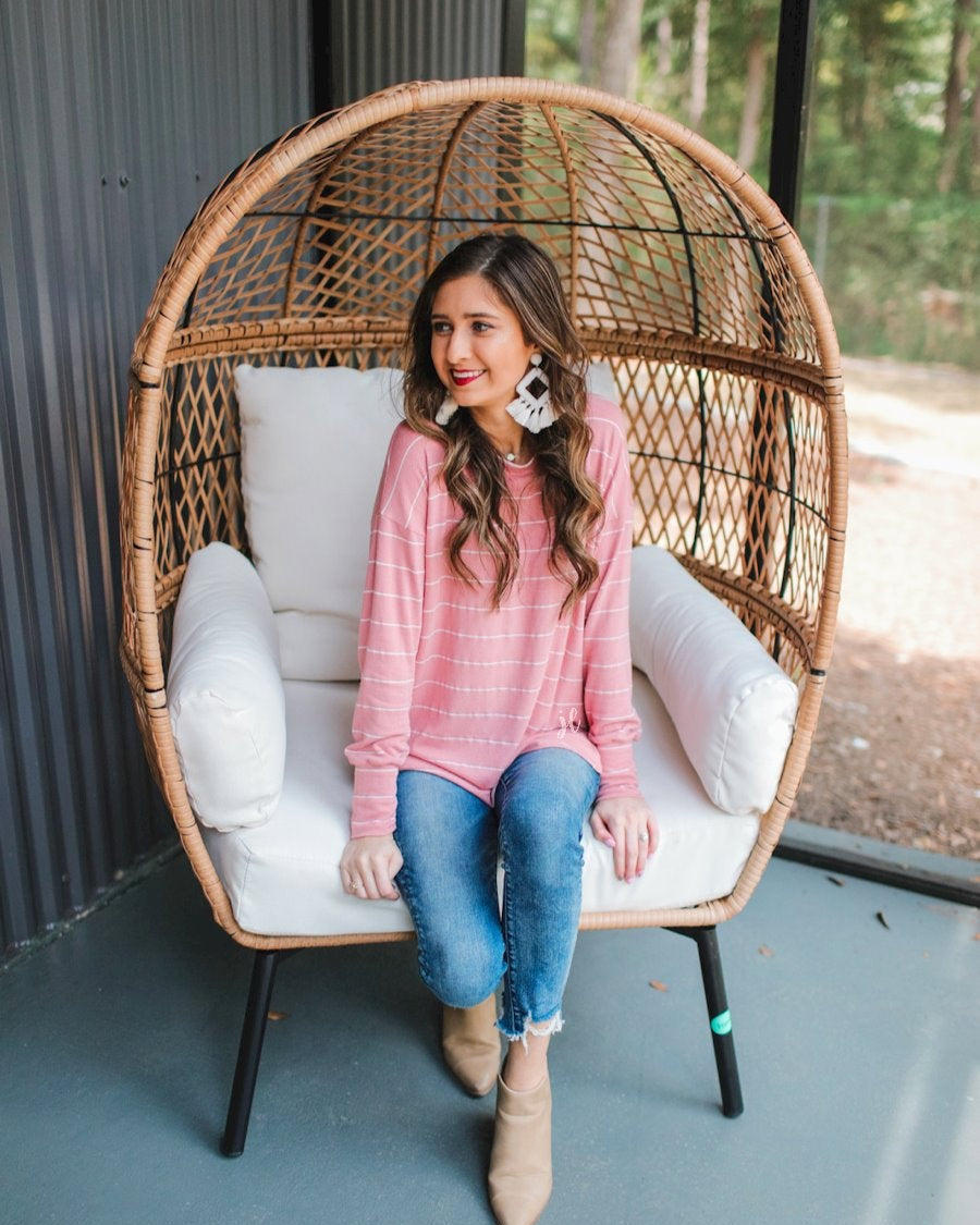 lightweight horizontal striped top with long sleeves, a crew neckline, and a slouched silhouette that ends in a rounded hemline on a solid mauve base