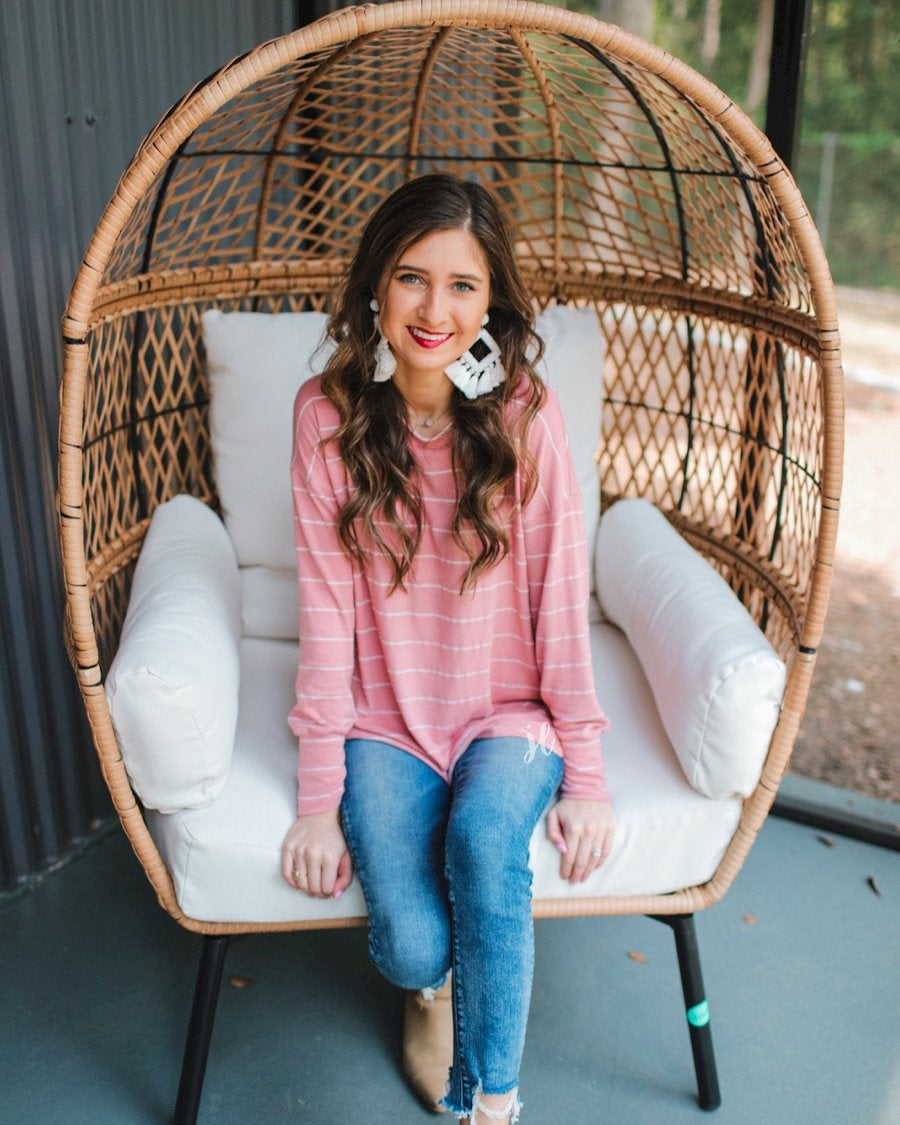 lightweight horizontal striped top with long sleeves, a crew neckline, and a slouched silhouette that ends in a rounded hemline on a solid mauve base