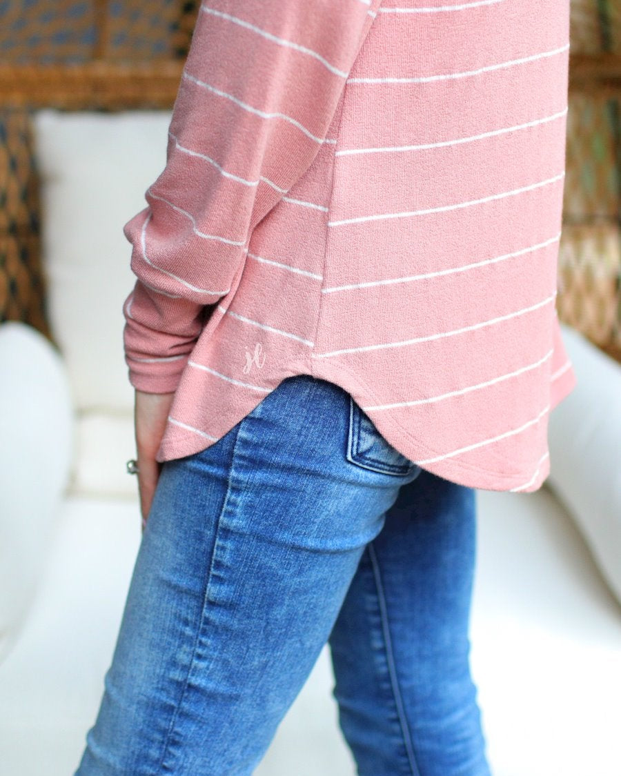 lightweight horizontal striped top with long sleeves, a crew neckline, and a slouched silhouette that ends in a rounded hemline on a solid mauve base