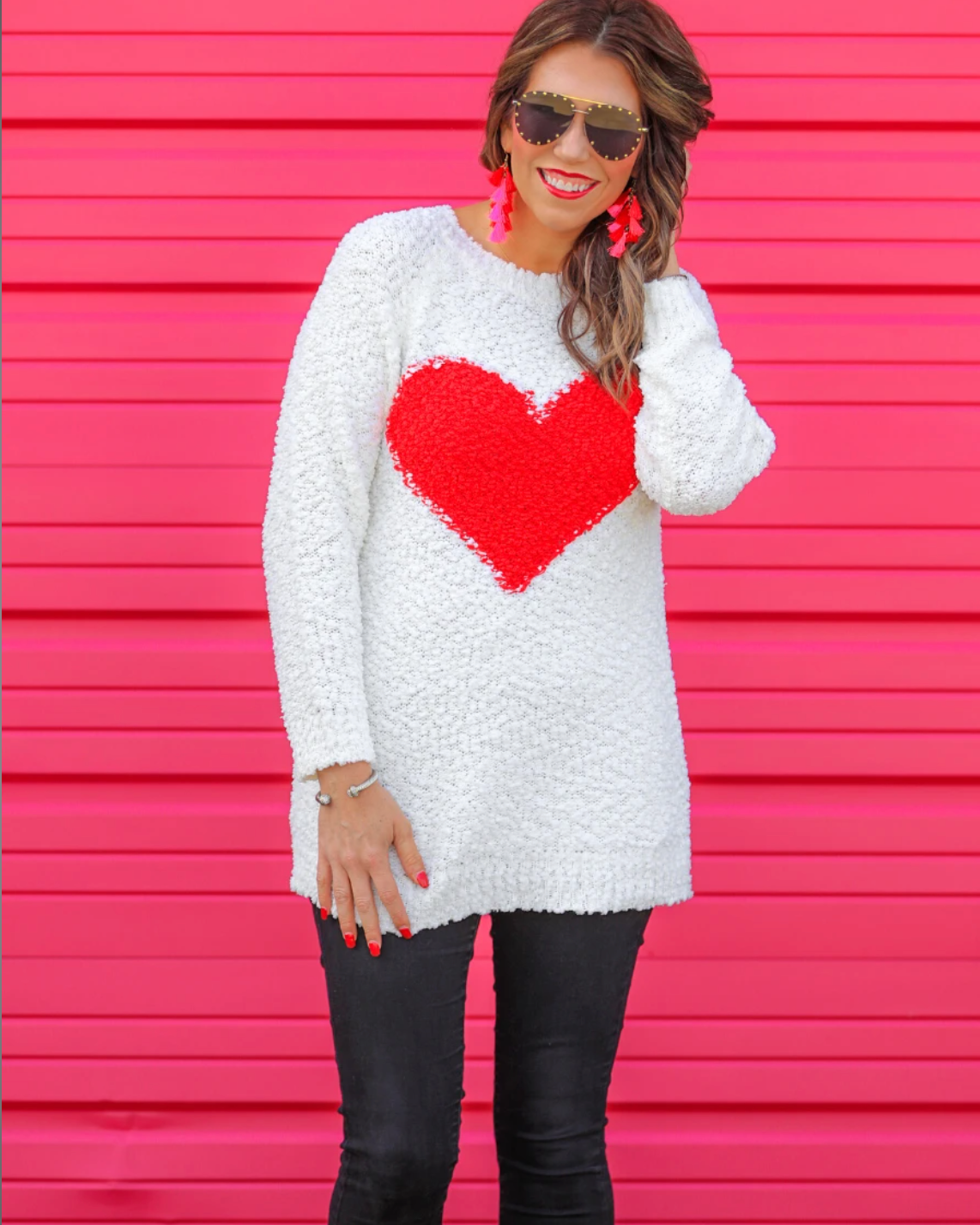 a long-sleeve crewneck sweater crafted from soft popcorn knit fabric and finished with an oversized contrasting red heart