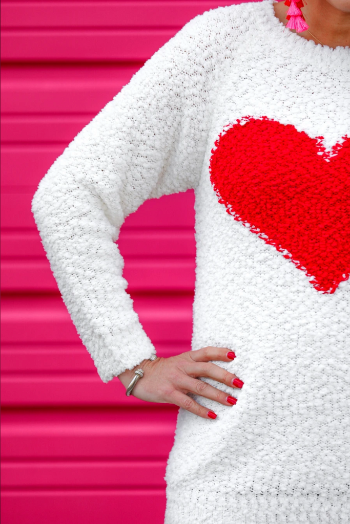 long sleeve crew neck sweater with an oversized contrasting red heart on popcorn fabric