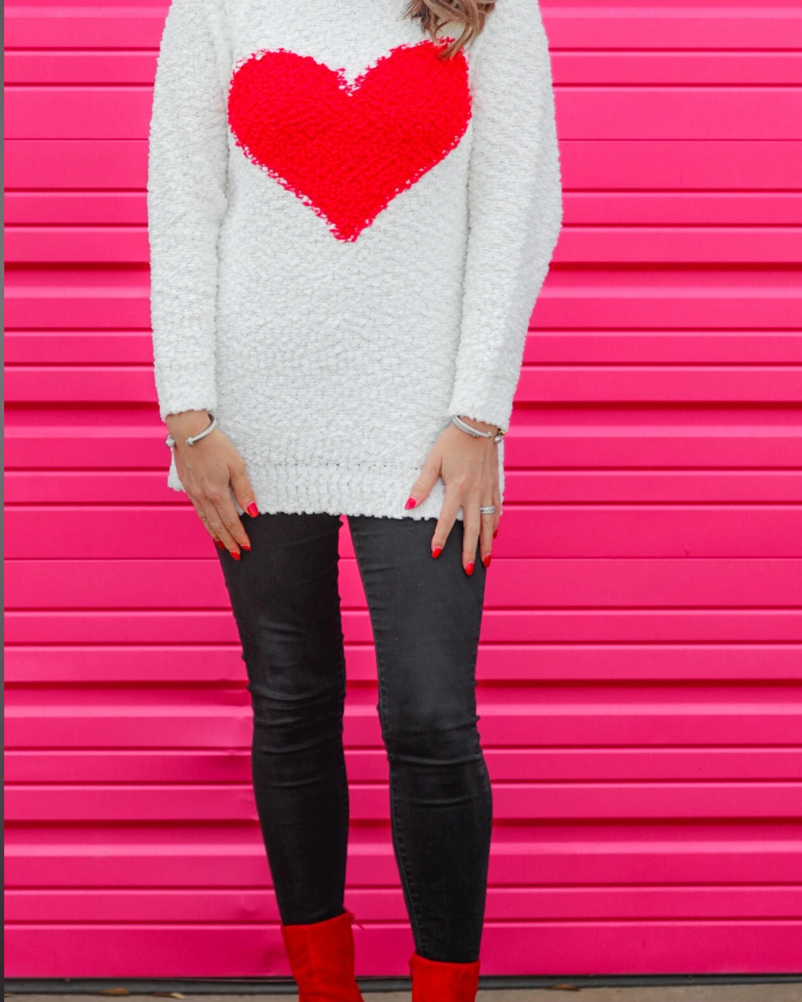 a long-sleeve crewneck sweater crafted from soft popcorn knit fabric and finished with an oversized contrasting red heart
