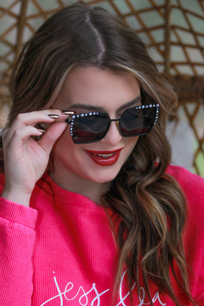 black square frames with pearl trim along the top and sides of the black frame, nose pads, UV protection, and brand name detail (on both the temple and the complimentary black pouch)