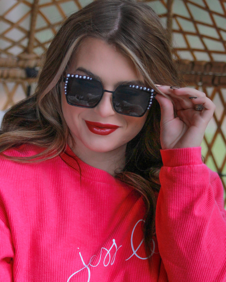 black square frames with pearl trim along the top and sides of the black frame, nose pads, UV protection, and brand name detail (on both the temple and the complimentary black pouch)