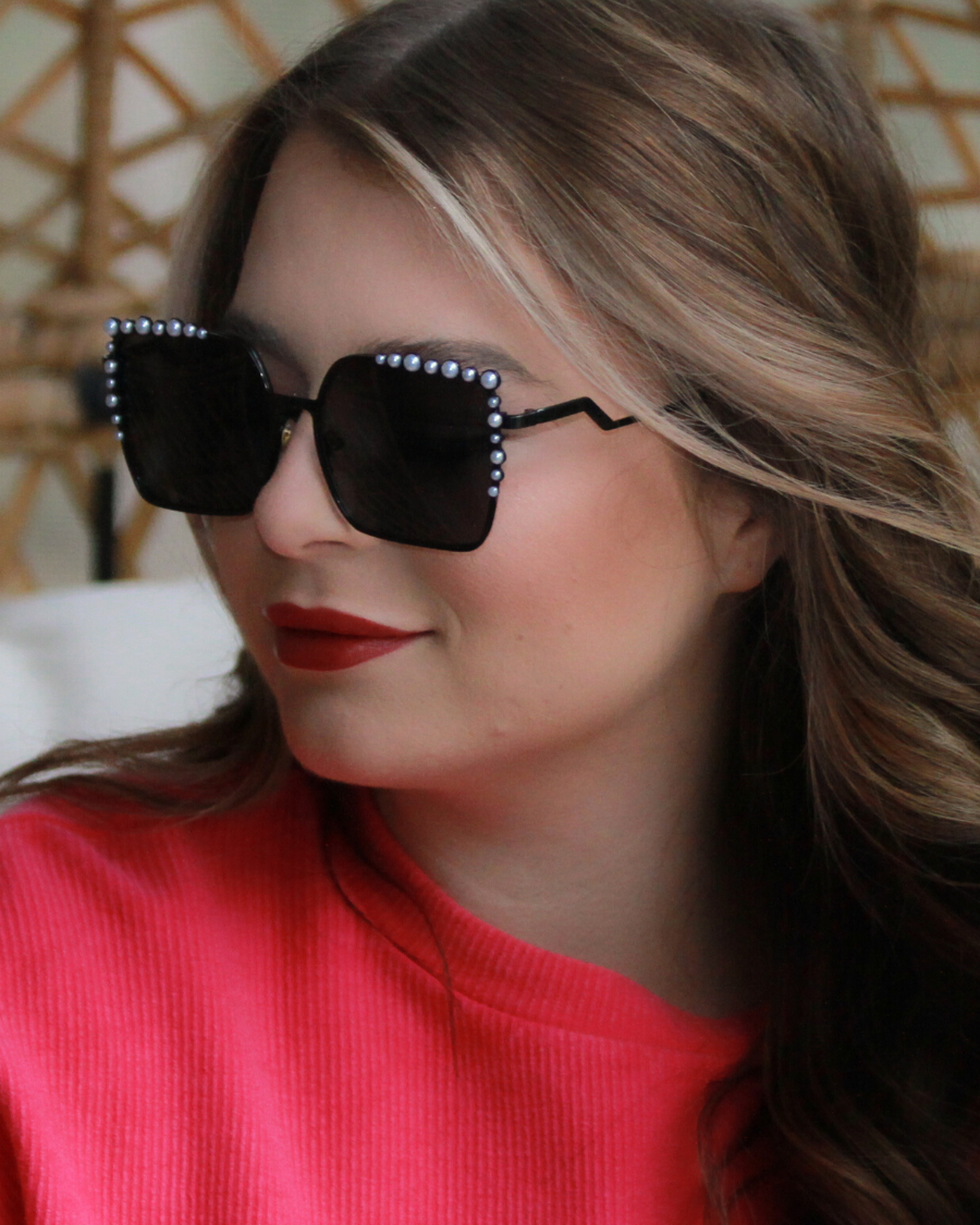 black square frames with pearl trim along the top and sides of the black frame, nose pads, UV protection, and brand name detail (on both the temple and the complimentary black pouch)