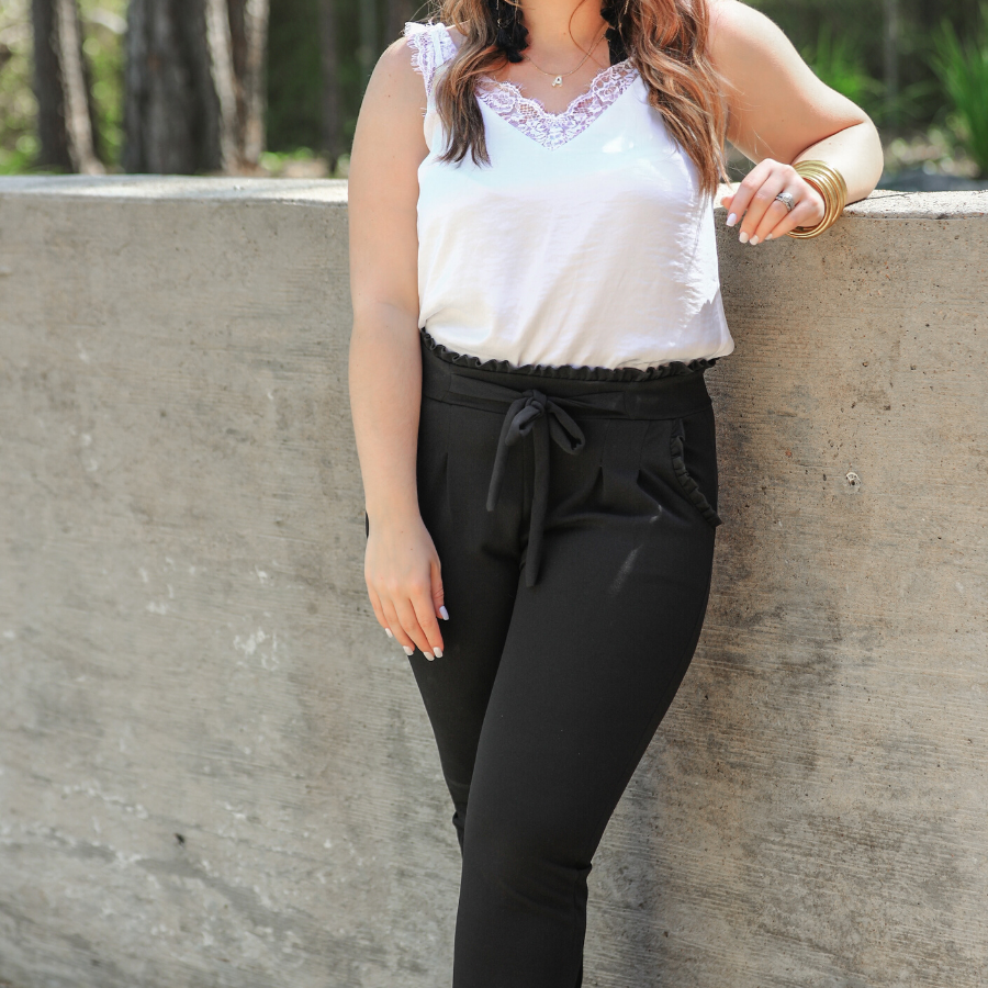 high-waisted paper-bag silhouette pants with a ruffle trim and sash tie, lightweight drapey fabric, straight legs, side pockets polished with a flirty ruffle, and unlined for breezy comfort in black