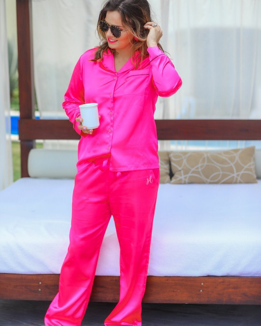 long sleeve button down front top with contrasting piping, a collared neckline, a single chest pocket, and a ribbon tie waist bottoms with side pockets made out of sleek lightweight silk material in pink