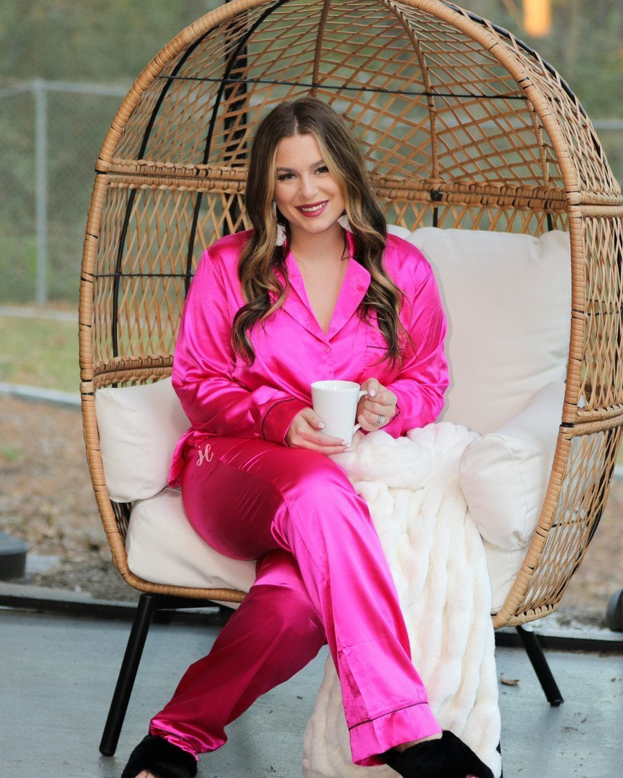 long sleeve button down front top with contrasting piping, a collared neckline, a single chest pocket, and a ribbon tie waist bottoms with side pockets made out of sleek lightweight silk material in pink