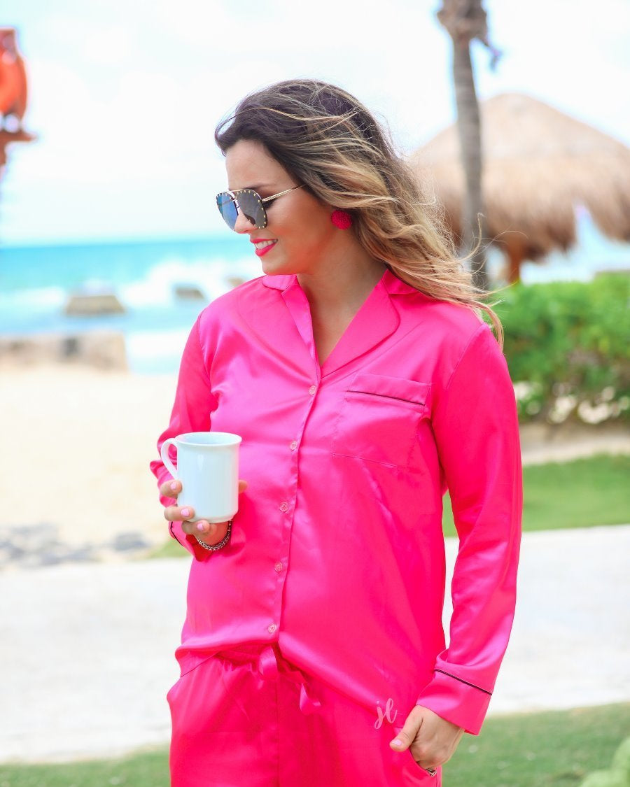 long sleeve button down front top with contrasting piping, a collared neckline, a single chest pocket, and a ribbon tie waist bottoms with side pockets made out of sleek lightweight silk material in pink