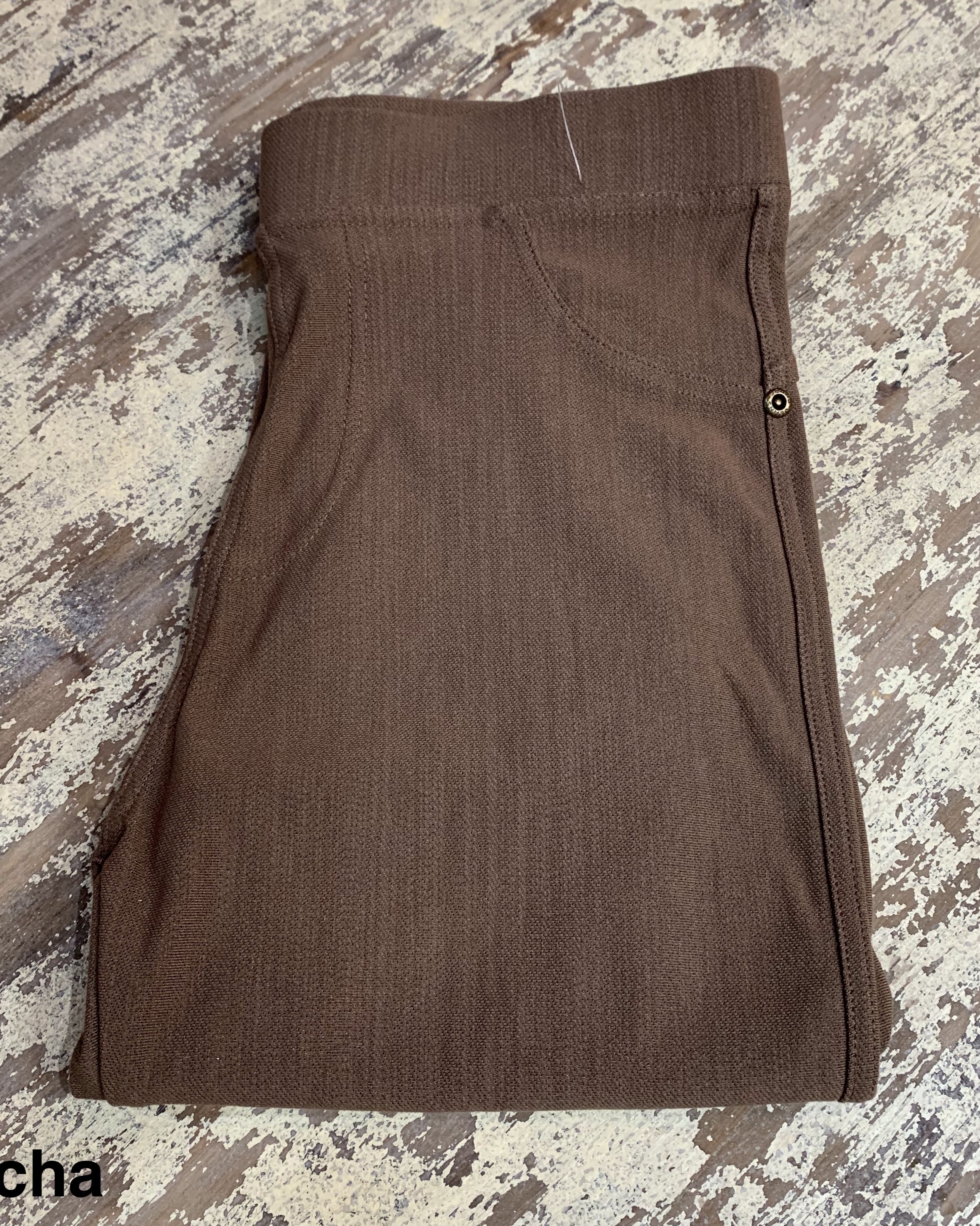 solid pull-on style leggings made of premium stretch fabric thicker than regular leggings, an elastic waistband, double back pockets, and a unique stripe detailing on the inside in mocha