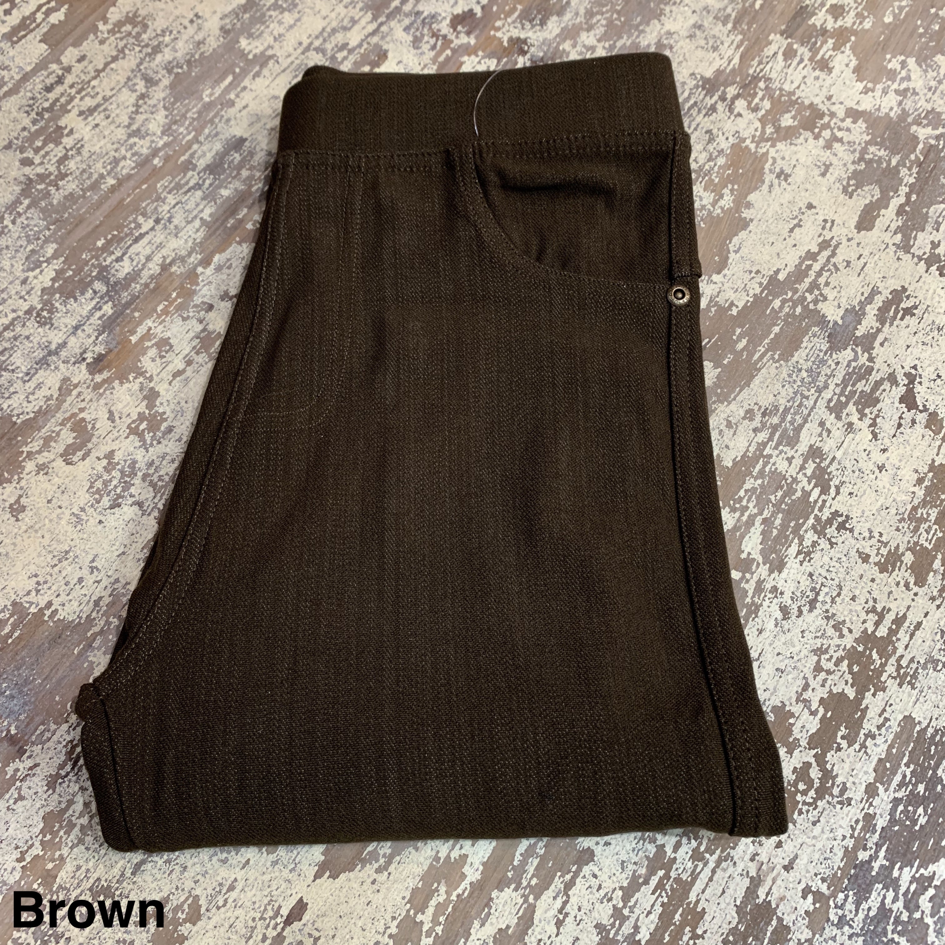 solid pull-on style leggings made of premium stretch fabric thicker than regular leggings, an elastic waistband, double back pockets, and a unique stripe detailing on the inside in brown