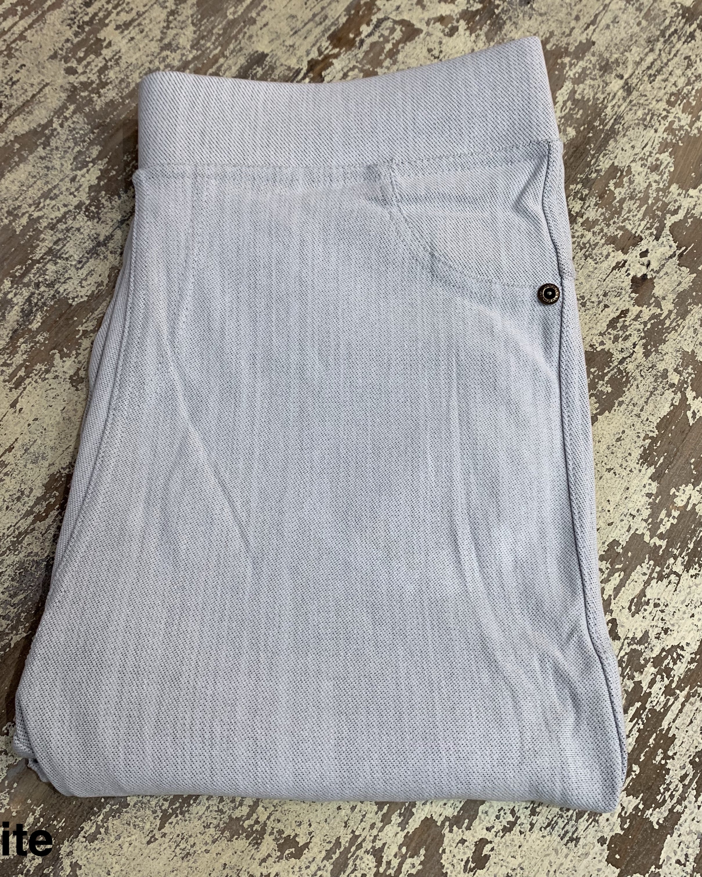 solid pull-on style leggings made of premium stretch fabric thicker than regular leggings, an elastic waistband, double back pockets, and a unique stripe detailing on the inside in white