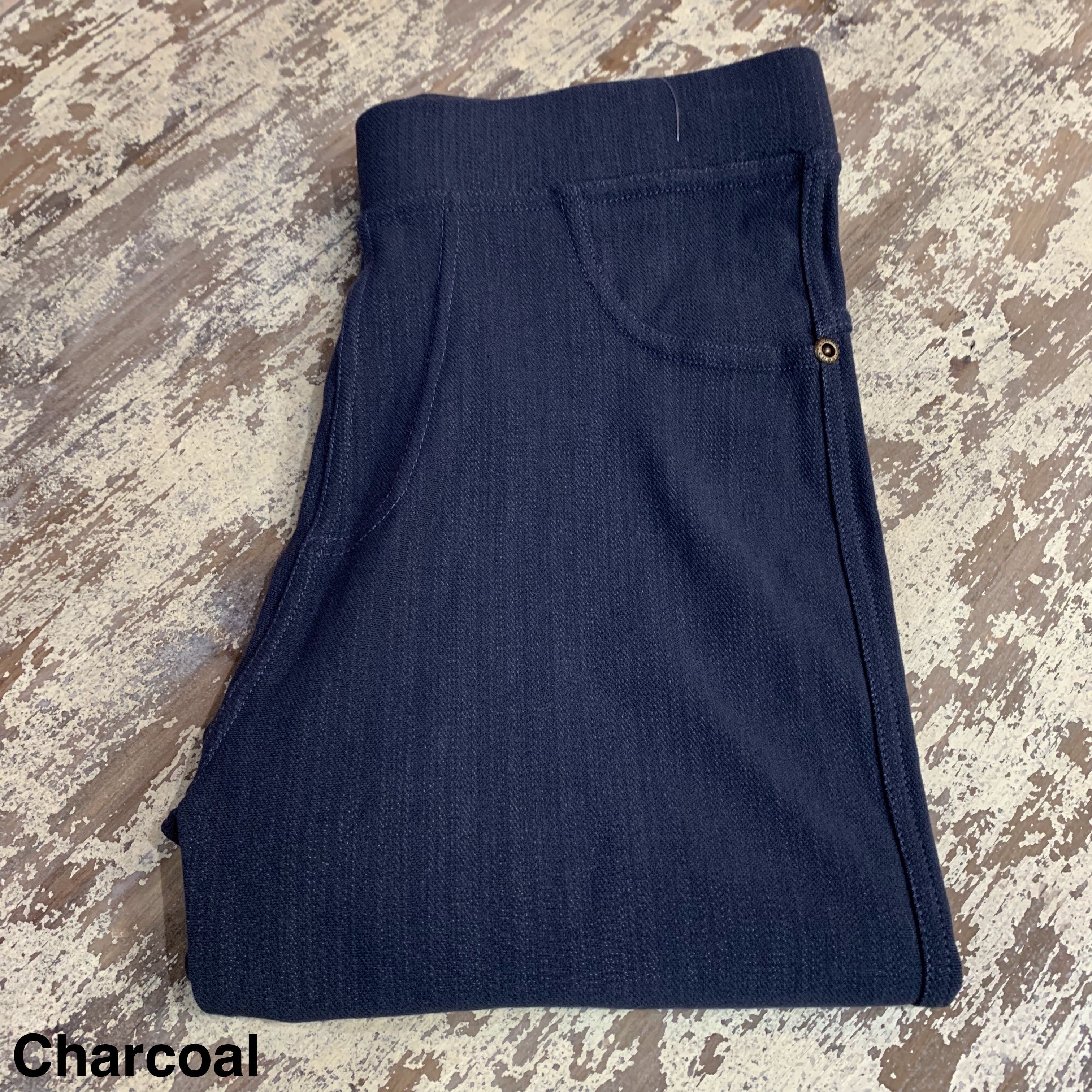 solid pull-on style leggings made of premium stretch fabric thicker than regular leggings, an elastic waistband, double back pockets, and a unique stripe detailing on the inside in charcoal