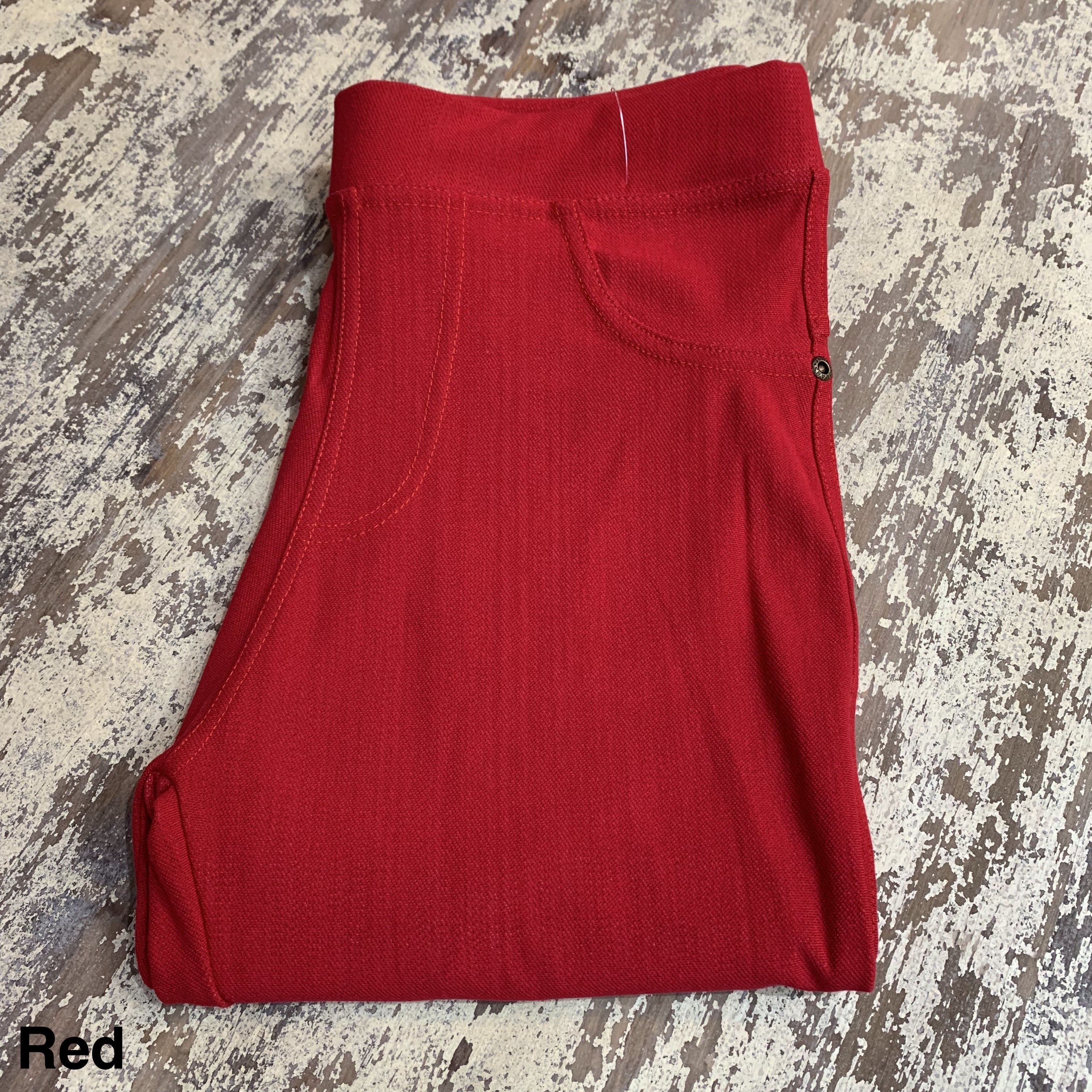 solid pull-on style leggings made of premium stretch fabric thicker than regular leggings, an elastic waistband, double back pockets, and a unique stripe detailing on the inside in red