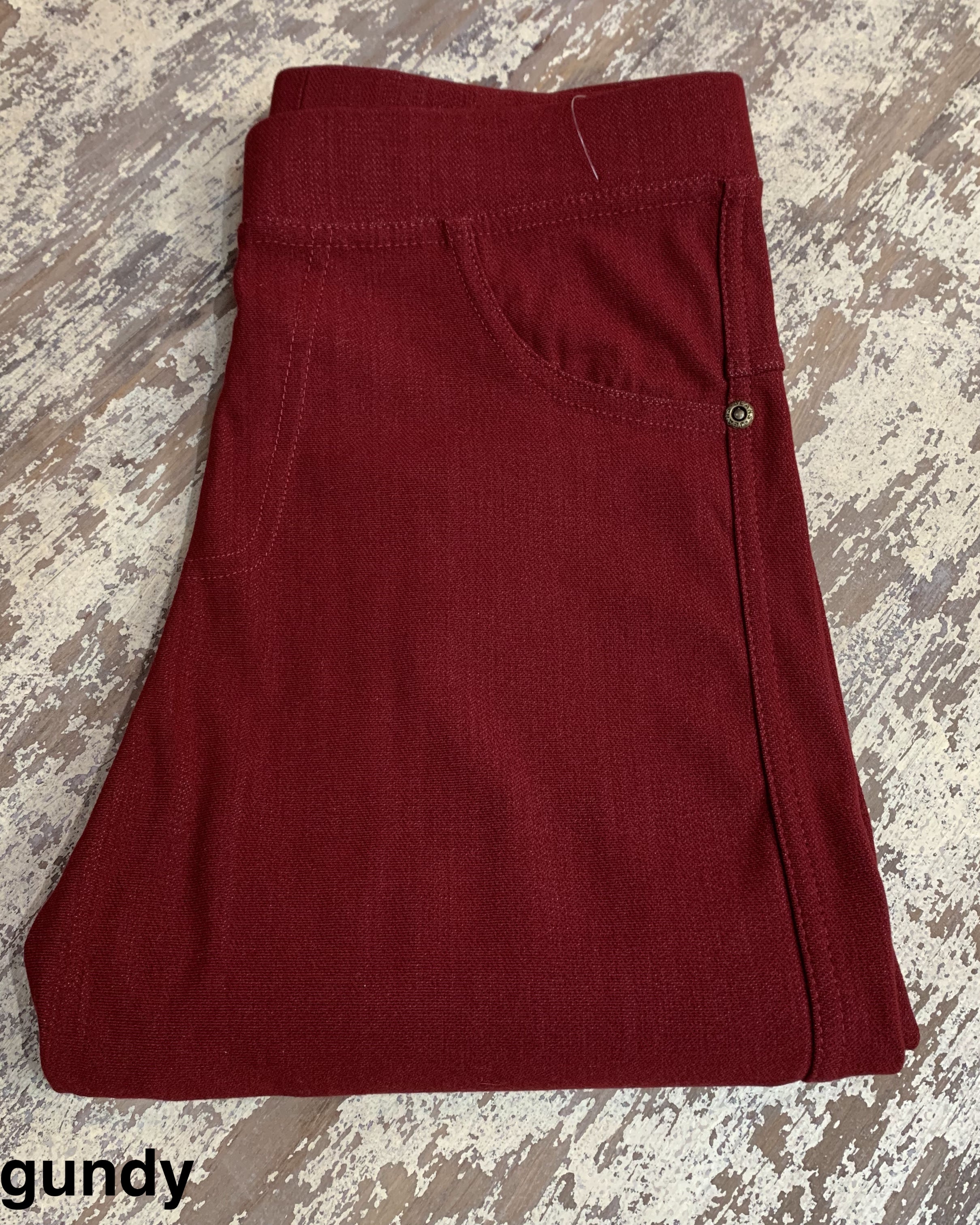 solid pull-on style leggings made of premium stretch fabric thicker than regular leggings, an elastic waistband, double back pockets, and a unique stripe detailing on the inside in burgundy