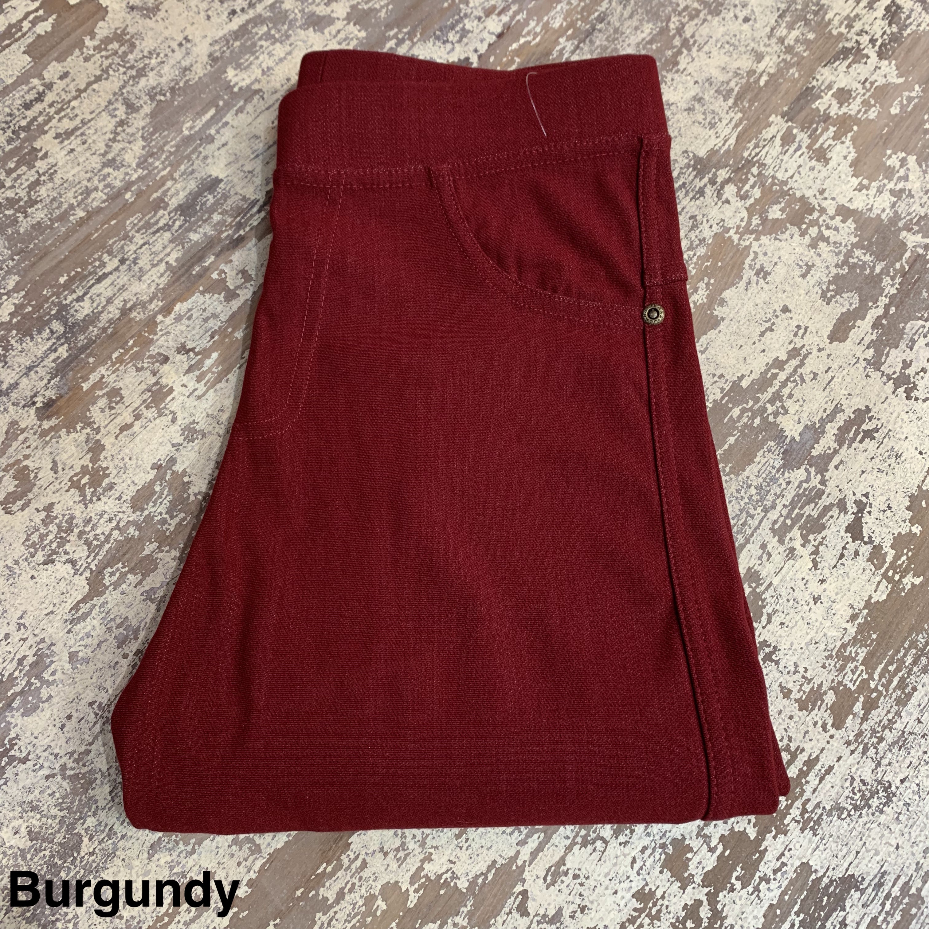 solid pull-on style leggings made of premium stretch fabric thicker than regular leggings, an elastic waistband, double back pockets, and a unique stripe detailing on the inside in burgundy