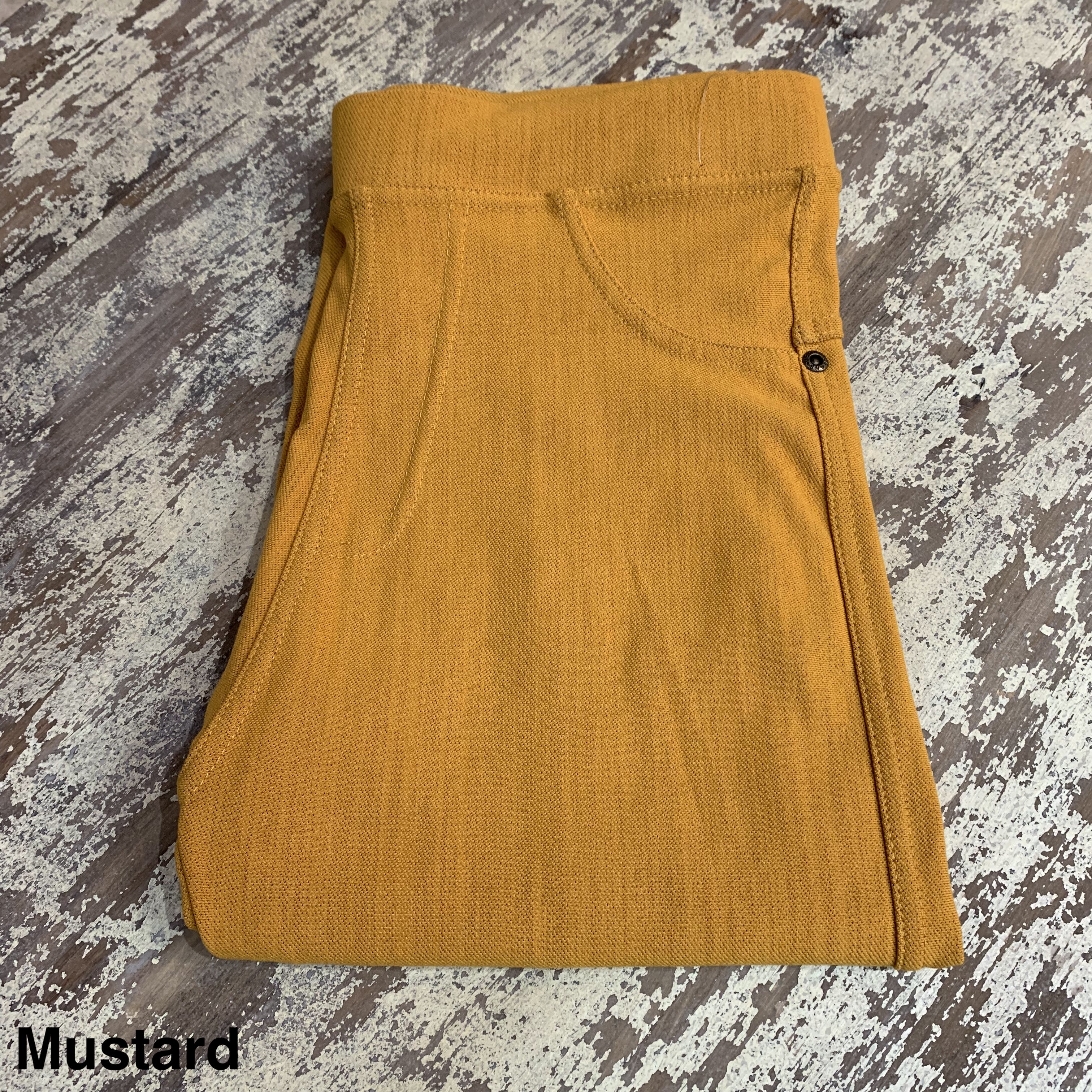 solid pull-on style leggings made of premium stretch fabric thicker than regular leggings, an elastic waistband, double back pockets, and a unique stripe detailing on the inside in mustard