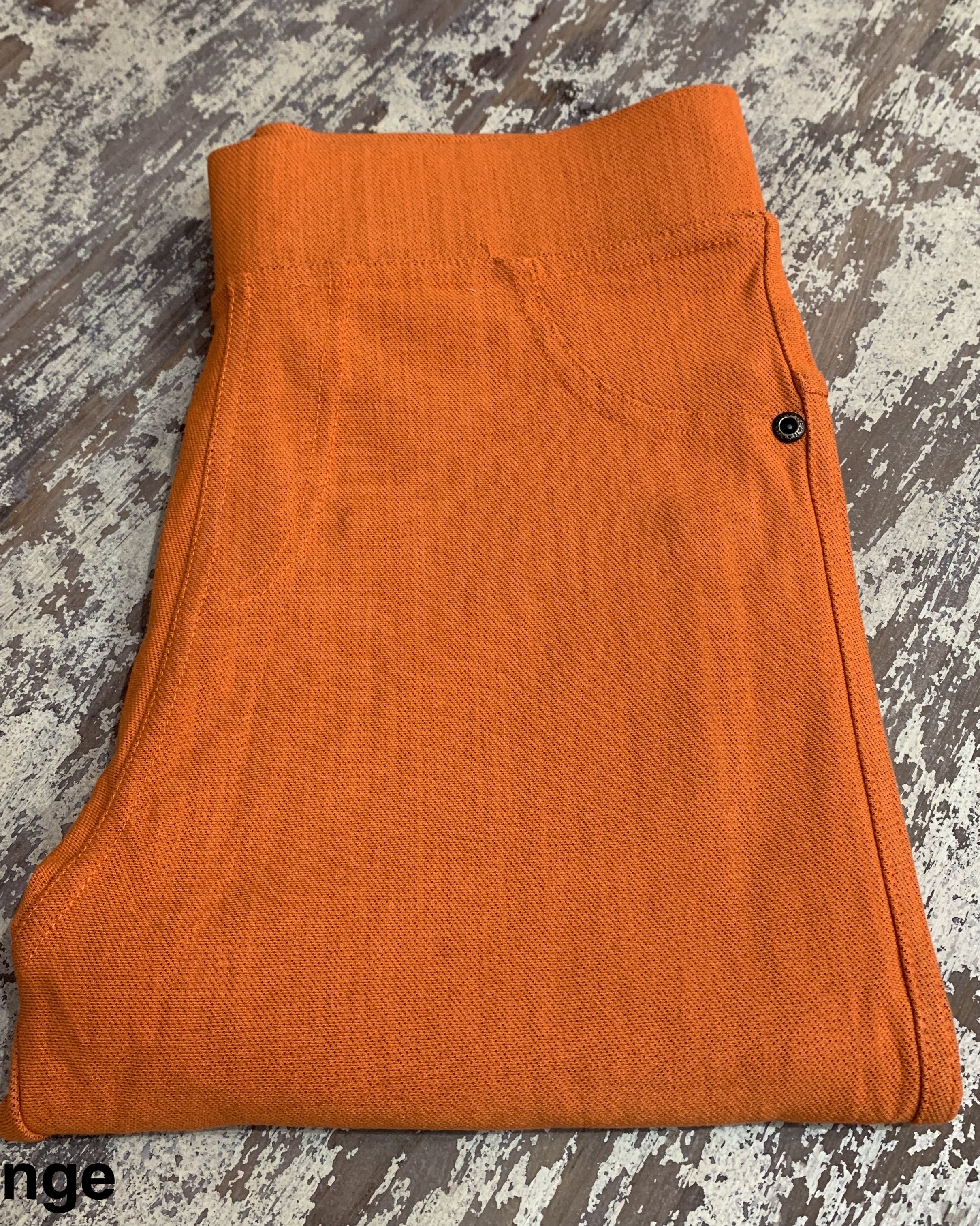 solid pull-on style leggings made of premium stretch fabric thicker than regular leggings, an elastic waistband, double back pockets, and a unique stripe detailing on the inside in orange