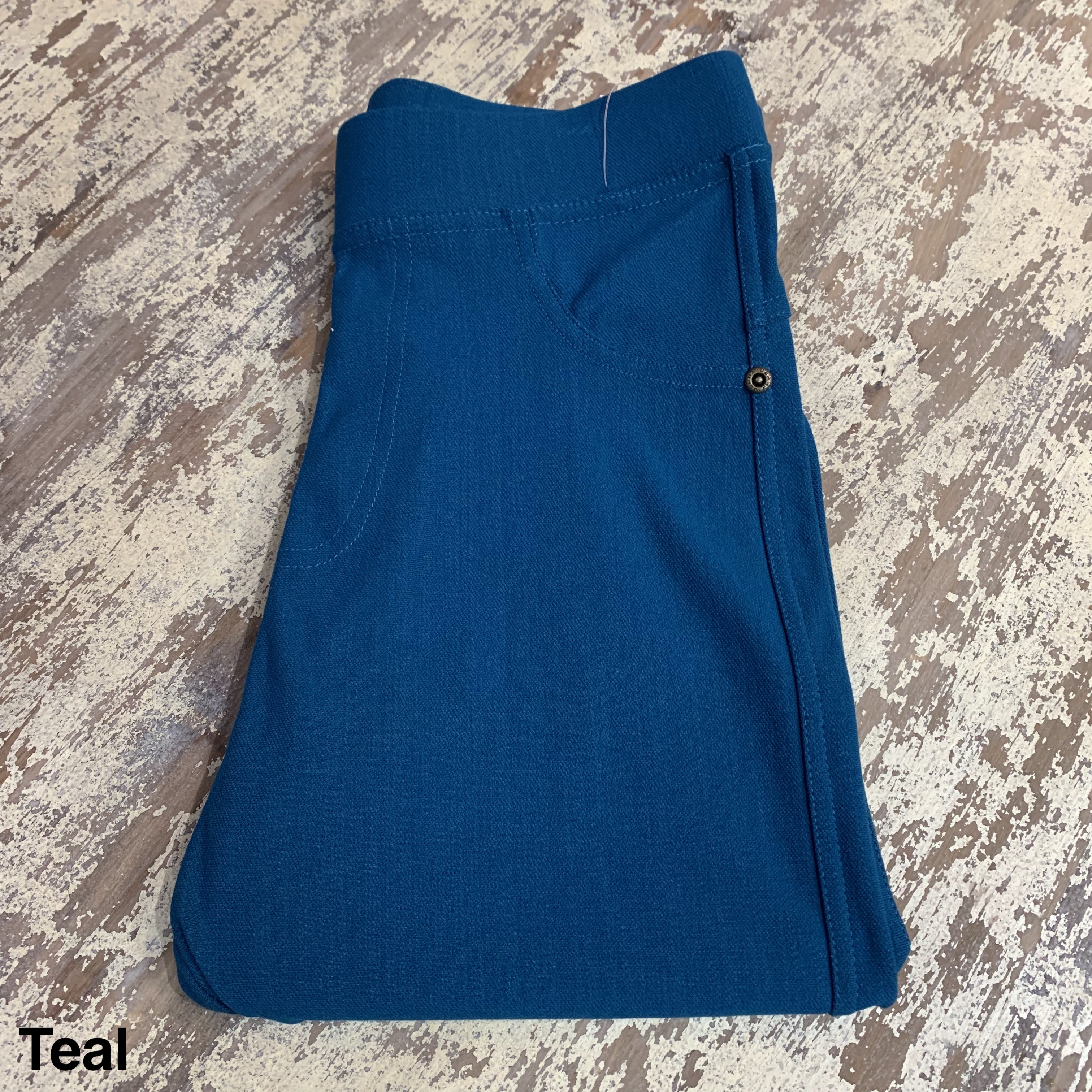 solid pull-on style leggings made of premium stretch fabric thicker than regular leggings, an elastic waistband, double back pockets, and a unique stripe detailing on the inside in teal