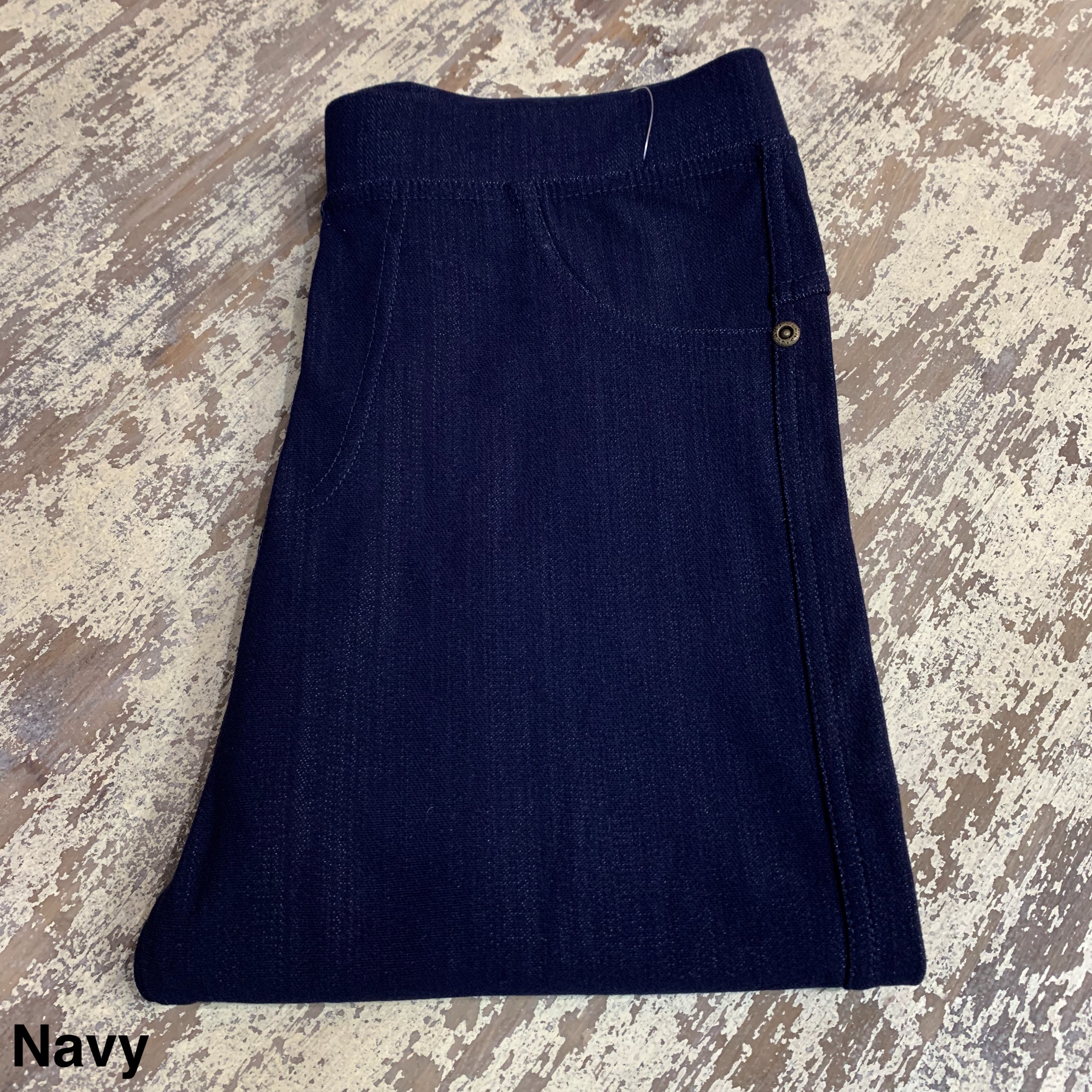solid pull-on style leggings made of premium stretch fabric thicker than regular leggings, an elastic waistband, double back pockets, and a unique stripe detailing on the inside in navy