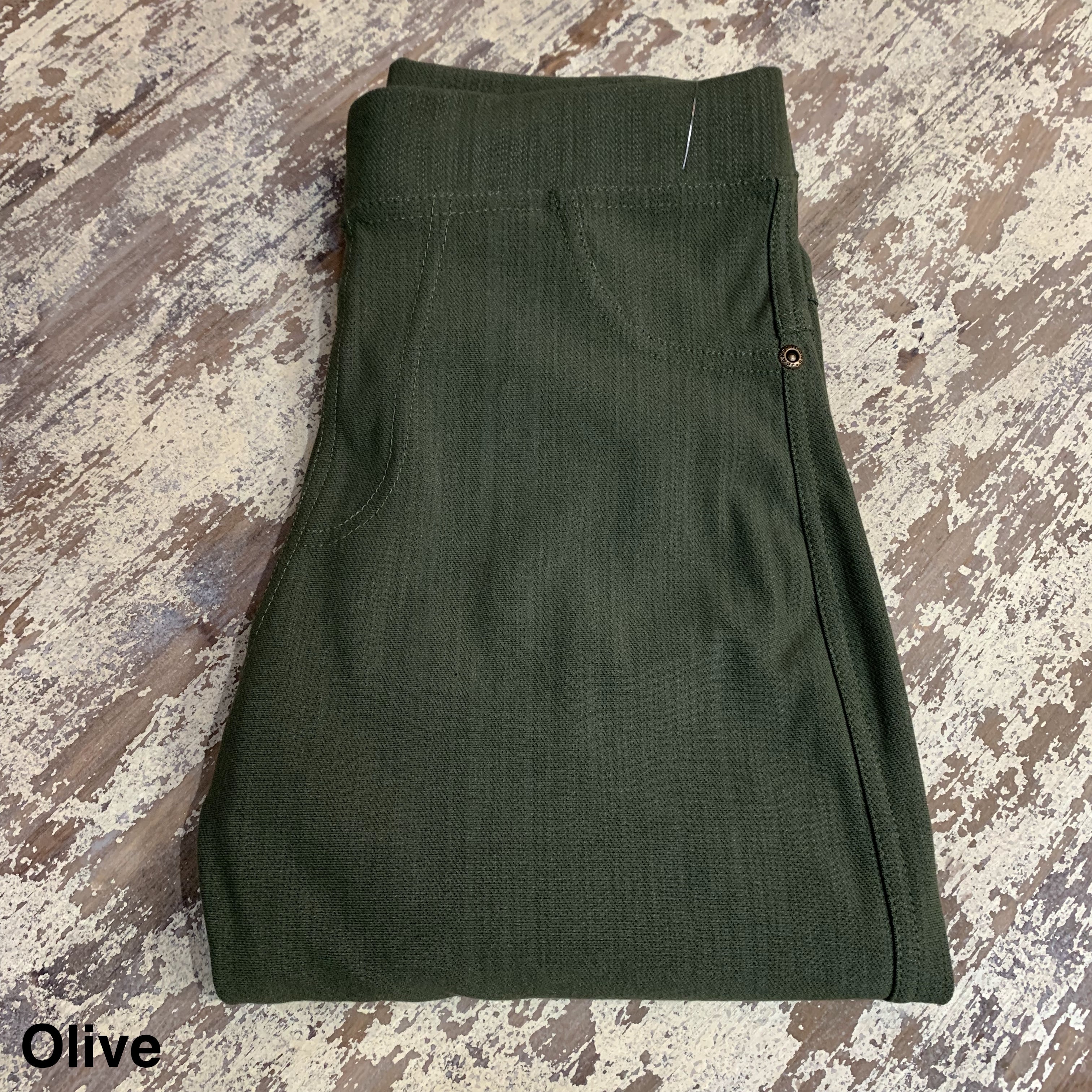 solid pull-on style leggings made of premium stretch fabric thicker than regular leggings, an elastic waistband, double back pockets, and a unique stripe detailing on the inside in olive