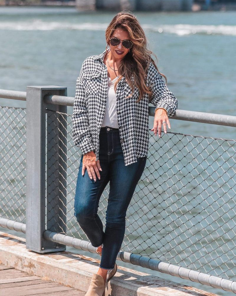 long sleeve drop shoulder shacket with button closures, a button-down front, a collared neckline, chest pockets, and back detailing on a black and white houndstooth print