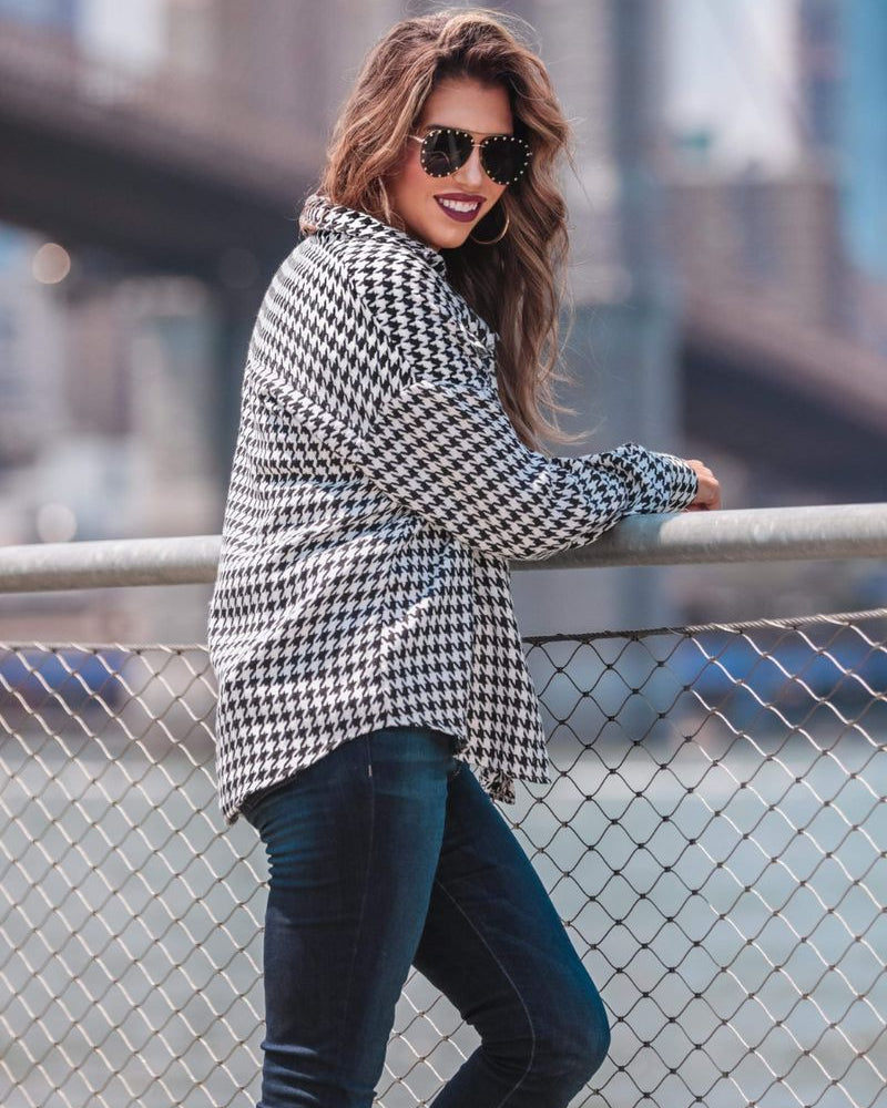 long sleeve drop shoulder shacket with button closures, a button-down front, a collared neckline, chest pockets, and back detailing on a black and white houndstooth print