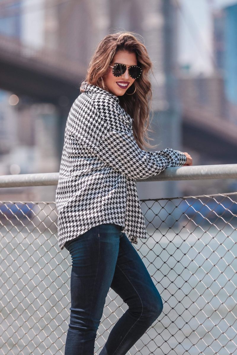long sleeve drop shoulder shacket with button closures, a button-down front, a collared neckline, chest pockets, and back detailing on a black and white houndstooth print