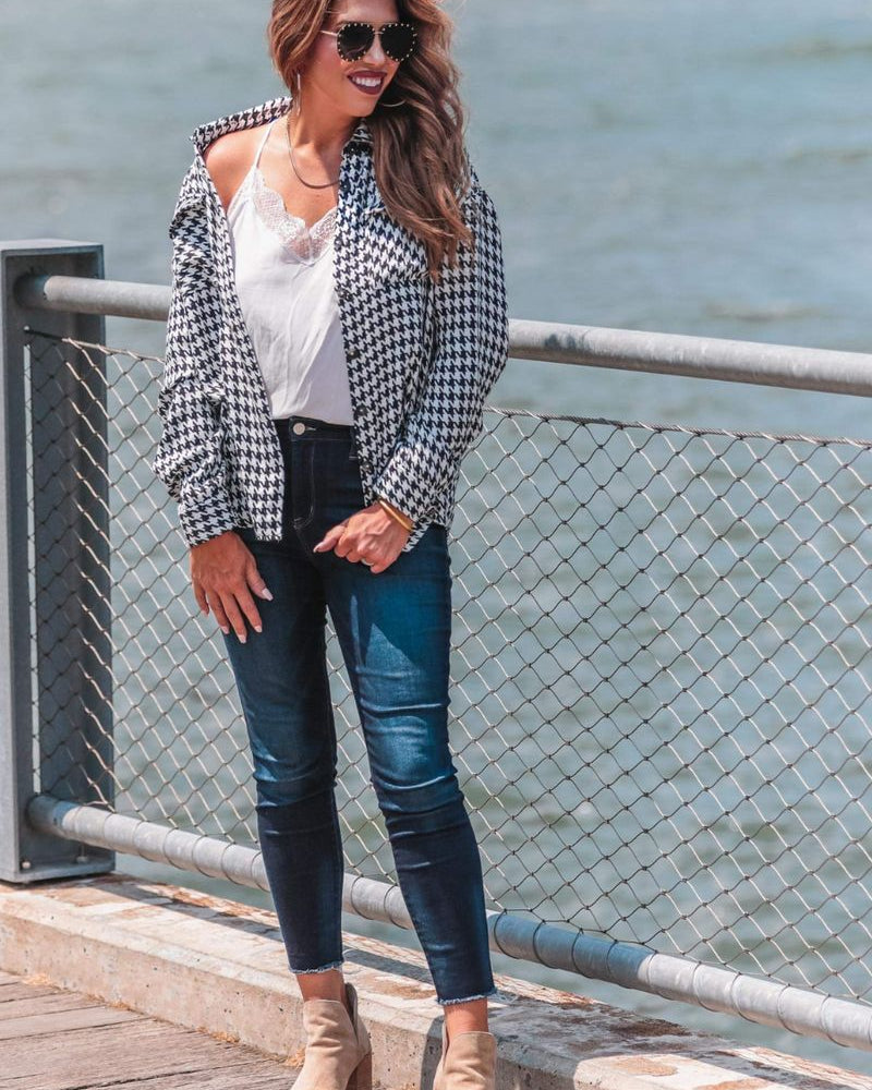 long sleeve drop shoulder shacket with button closures, a button-down front, a collared neckline, chest pockets, and back detailing on a black and white houndstooth print