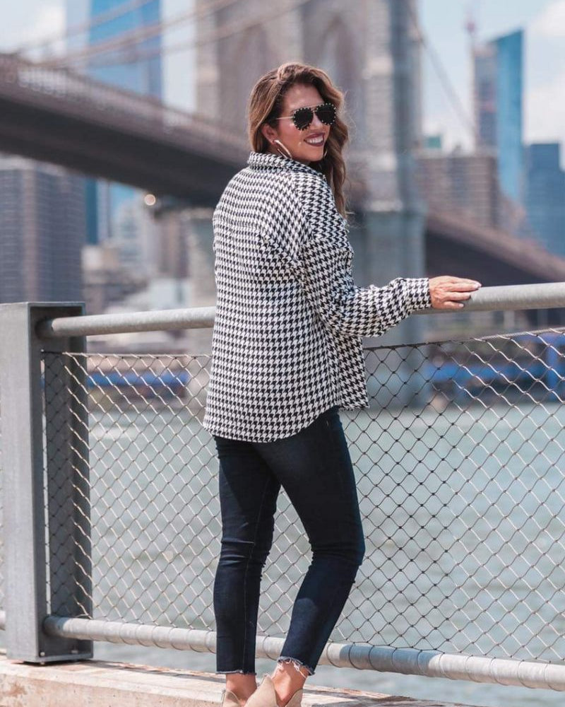 long sleeve drop shoulder shacket with button closures, a button-down front, a collared neckline, chest pockets, and back detailing on a black and white houndstooth print