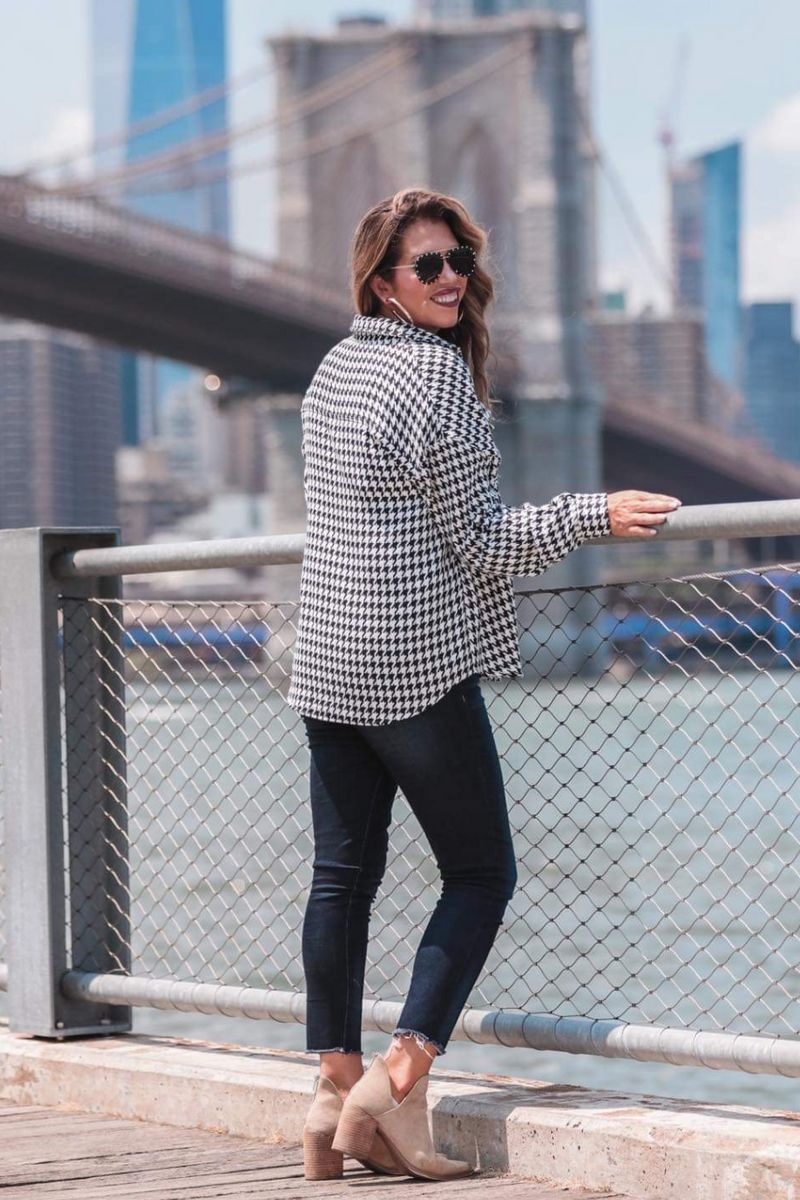 long sleeve drop shoulder shacket with button closures, a button-down front, a collared neckline, chest pockets, and back detailing on a black and white houndstooth print