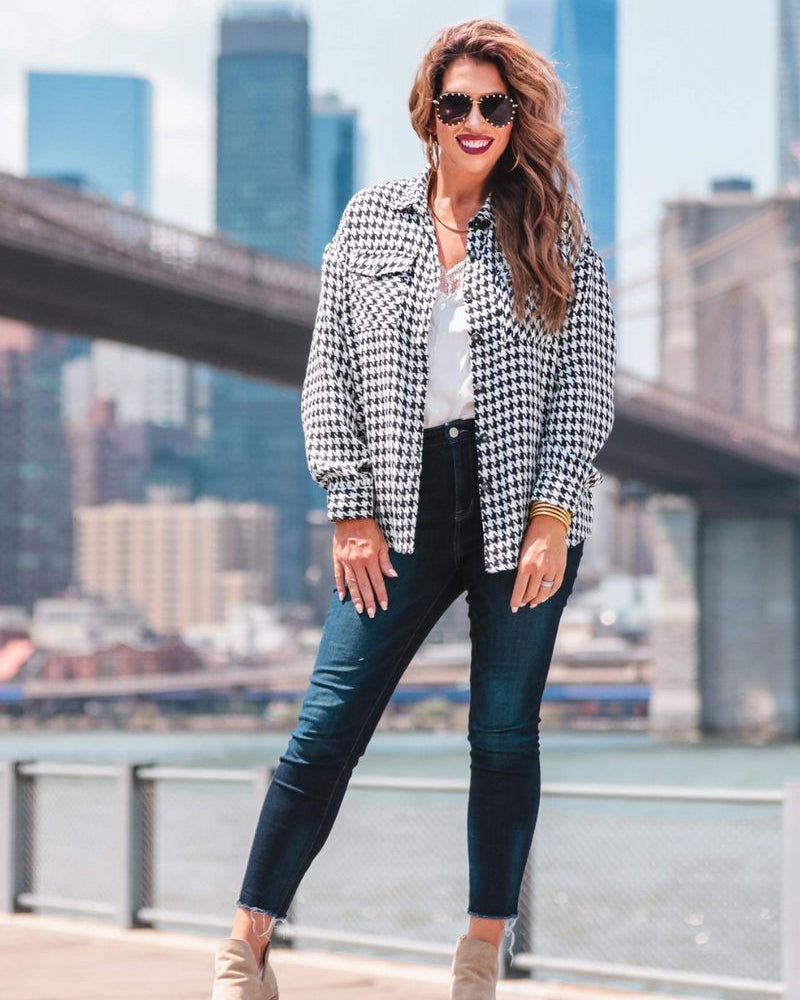 long sleeve drop shoulder shacket with button closures, a button-down front, a collared neckline, chest pockets, and back detailing on a black and white houndstooth print