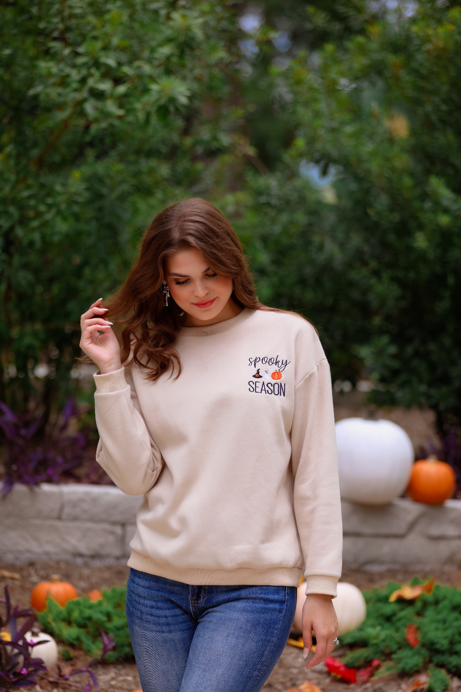 a tan long-sleeve sweatshirt crafted from soft fabric with black embroidered 'spooky SEASON' chest lettering, mini witch hat, ghost, and pumpkin accents, crew neckline, dropped shoulders, ribbed cuffs, banded hem, and a relaxed fit