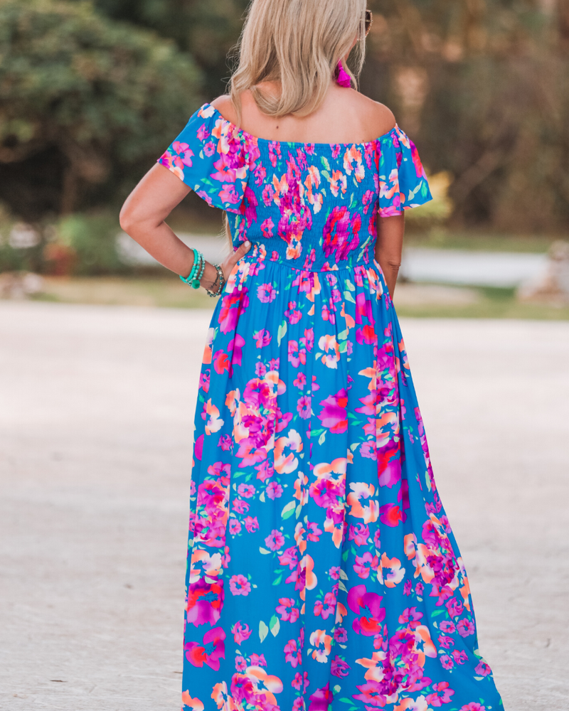 an off-the-shoulder floral dress made of lightweight material with ruffle sleeves, a stretchy smocked back, and interior lining in blue